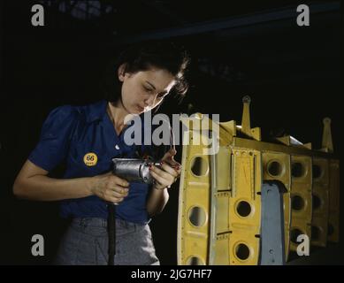 Drilling horizontal stabilizers: operating a hand drill, this woman worker at Vultee-Nashville is shown working on the horizontal stabilizer for a Vultee &quot;Vengeance&quot; dive bomber, Tennessee. The &quot;Vengeance&quot; (A-31) was originally designed for the French. It was later adopted by the R.A.F. and still later by the U.S. Army Air Forces. It is a single-engine, low-wing plane, carrying a crew of two men and having six machine guns of varying calibers. Stock Photo