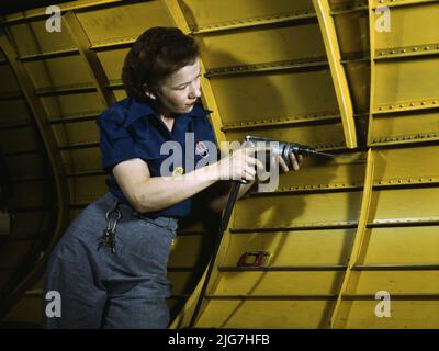 Operating a hand drill at Vultee-Nashville, woman is working on a &quot;Vengeance&quot; dive bomber, Tennessee. Stock Photo