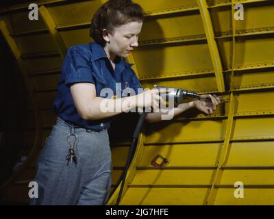 Operating a hand drill at Vultee-Nashville, woman is working on a &quot;Vengeance&quot; dive bomber, Tennessee. Stock Photo