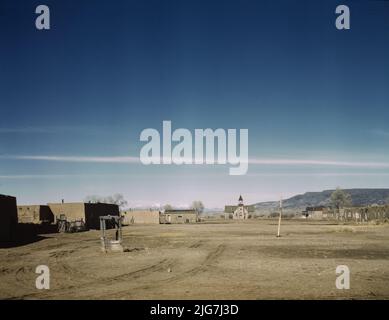 Plaza of Costilla, near the Colorado line, New Mexico. Photo shows the plaza of Costilla, New Mexico, on the east side of Route 522. [Adobe houses; well in foreground]. Stock Photo