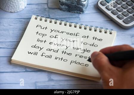 Motivational and inspirational quote - Put yourself at the top of your to-do list every single day and the rest will fall into place. Hand writing on Stock Photo