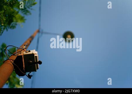 Selective focus of a switch street light attached on a metal pole. Low angle view. Stock Photo