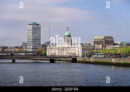City landscape with landmarks of Dublin visible on the horizon. The Custom House, the Spire and the Liberty Hall by the River Liffey on sunny day. Stock Photo