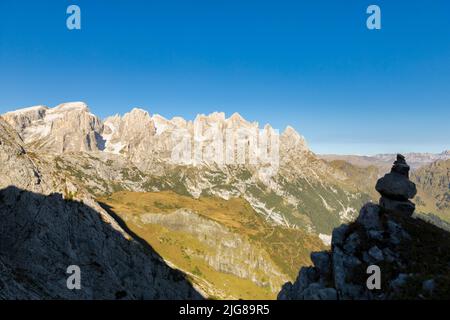 Italy, Veneto, Belluno, Canale d'Agordo, a stoneman or cairn with the mountain ridge of Pale di San Martino in the background Stock Photo