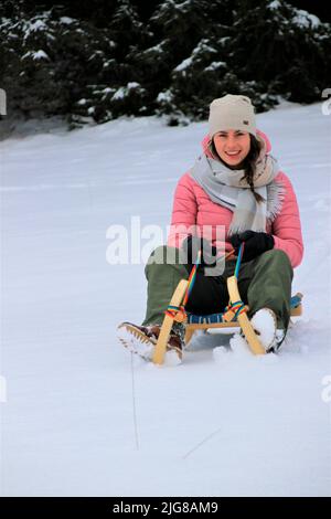 Young woman on winter hike near Mittenwald, sledge in front of mountain scenery in snow, Bavaria, Upper Bavaria, Germany, vacation, winter, Stock Photo