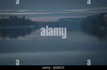 An aerial view of lake surrounded by growing lush trees with reflection ...