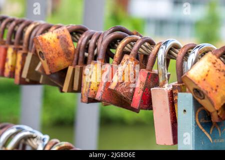 Love locks hang on the chain bridge in Bamberg Stock Photo