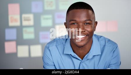Dont be fooled by my youth. Portrait of a businessman with sticky notes up on a board behind him. Stock Photo