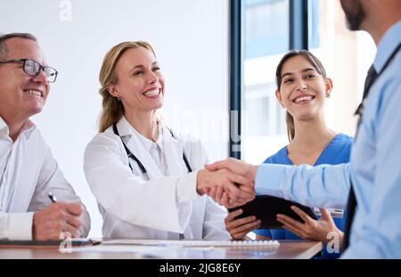 the medical world is bigger than I thought. Shot of two doctors shaking hands in a meeting at a hospital. Stock Photo