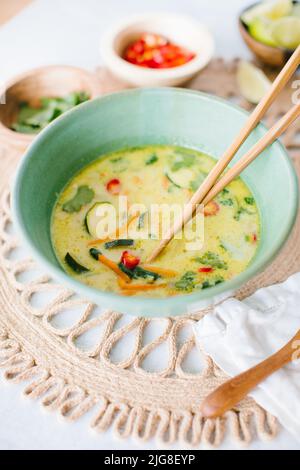 A closeup of Thai coconut soup with garnishes Stock Photo