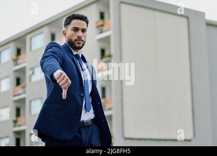 I dont need this now. Shot of a young businessman giving the thumbs down. Stock Photo