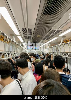 A vertical shot of a busy metropolitan subway with people wearing masks in Jongno-gu Seoul South Korea Stock Photo