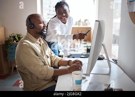 An operation is only as successful as its staff. Shot of a businessman and businesswoman using a headset and computer while working in a modern office Stock Photo