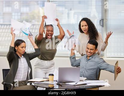 Sometimes frustration needs to be released. Shot of a group of businesspeople angrily throwing paperwork around. Stock Photo