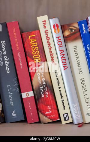 A row of books including Stieg Larsson's The Girl With The Dragon Tattoo placed on a bookshelf Stock Photo