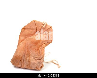 Old tea bag against white background Stock Photo