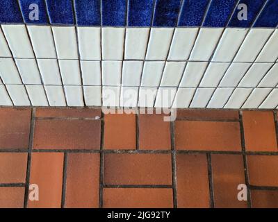 Ceramic white and blue wall tile and brown tile floor pattern