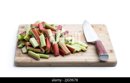 Chopped  rhubarb stalks on wooden board isolated on white Stock Photo