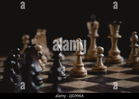 Chess board game in progress from a side view perspective. Carved chess ...