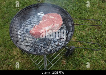 Piece of beef with coarse salt and rosemary ready to go on the BBQ Stock Photo
