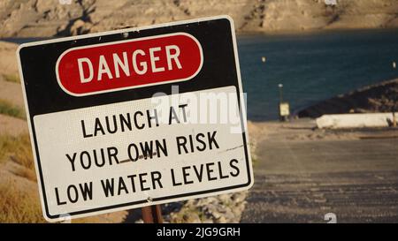 Lake Mead, USA. 8th July, 2022. Photo taken on July 5, 2022 shows a sign warning people about the danger to launch boats due to low water levels near Echo Bay, Lake Mead, Nevada, the United States. Surrounded by a white band of dried rocks, the vast drop in water levels is visible this week at Lake Mead, the biggest reservoir in the United States, which has been shrinking amid a two-decade-long megadrought. Credit: Zeng Hui/Xinhua/Alamy Live News Stock Photo