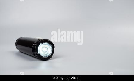 led flashlight on gray background with copy space. Stock Photo
