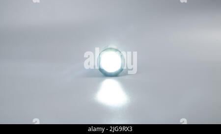 led flashlight on gray background, travel light source. Stock Photo