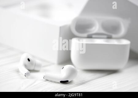 KHARKIV, UKRAINE - JANUARY 27, 2021: Apple AirPods Pro on a white background. Wireless headphones with charging case and a box. Apple Inc. is an Ameri Stock Photo