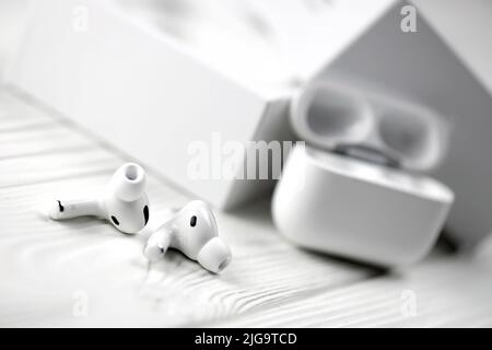 KHARKIV, UKRAINE - JANUARY 27, 2021: Apple AirPods Pro on a white background. Wireless headphones with charging case and a box. Apple Inc. is an Ameri Stock Photo
