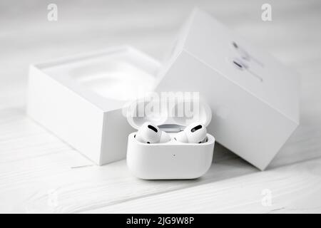 KHARKIV, UKRAINE - JANUARY 27, 2021: Apple AirPods Pro on a white background. Wireless headphones with charging case and a box. Apple Inc. is an Ameri Stock Photo