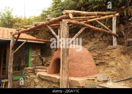 Pizza oven homemade in the garden with a wooden roof. Open fire pizza oven Stock Photo