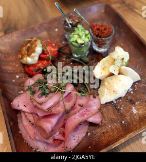 Bacon, cheese, tomato and pastry on the wooden breakfast plate. Stock Photo