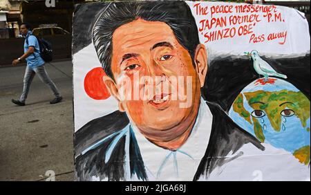 Mumbai, India. 08th July, 2022. A man is seen walking behind a painting of the former Japanese Prime Minister Shinzo Abe in Mumbai. Shinzo Abe was shot dead during an election campaign in the city of Nara. Credit: SOPA Images Limited/Alamy Live News Stock Photo