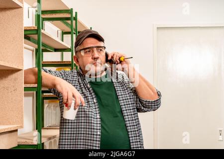 Professional talking seriously on cell phone while working on a construction site. Concept of work, builder, worker. Stock Photo