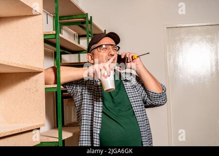 Professional talking seriously on cell phone while working on a construction site. Concept of work, builder, worker. Stock Photo