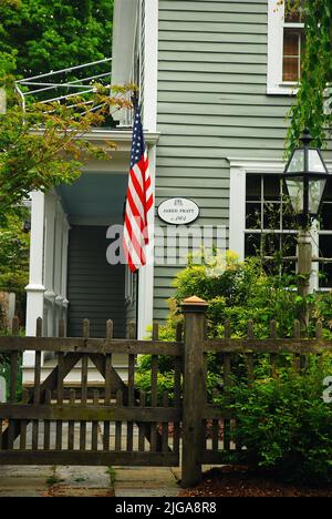 An American flag hangs from the front of the historic Jared Pratt House, one of many historical homes in Essex, Connecticut, New England Stock Photo