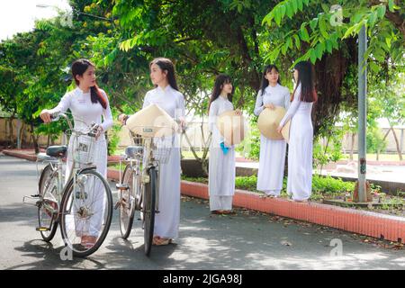 Ho Chi Minh City, Vietnam - September 13rd, 2015: Beauty students in the school hallway with white long dress and the hat leaves creating beauty stude Stock Photo