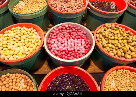 A pile of shiny Syrian green olives, full of oil. No kernels. Blurred background. Arabic style. The Old Market of Mahane Yehuda, Jerusalem. Stock Photo
