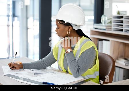 Focused on the task ahead. a female engineer drawing up blueprints. Stock Photo