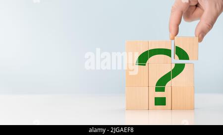 Question marks on Cubes green color, closeup. Space for text. hand hold Questions Mark word with wooden cube. Problem, solution, counseling. FAQ frequ Stock Photo