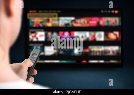 man relaxing at home in evening and watching TV. Multimedia streaming concept. VoD content provider. Video service with internet streaming multimedia Stock Photo