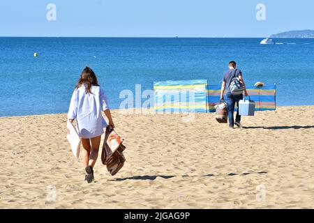 Boscombe, Bournemouth, Dorset, England, UK, 9th July 2022, Weather. Heatwave. People arrive at the beach before 8.30 am on Saturday morning. Temperatures will reach the high 20s by afternoon in wall-to-wall sunshine. People setting up un the beach. Credit: Paul Biggins/Alamy Live News Stock Photo