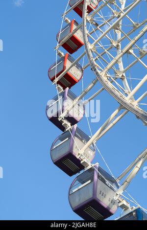 Closeup of multicolored Tempozan Ferris Wheel in amusement park with blue sky in Tbilisi, Georgia Stock Photo