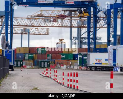 Belfast Docks busy with moving a container box in mid air to be loaded on to a waiting container ship ready for export Stock Photo