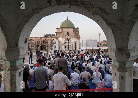 Mosul, Iraq. 09 July 2022, Iraq, Mosul: Muslims perform prayers of Eid al-Adha, the holiest feast in Islam, at the courtyard of the Great Mosque of al-Nuri, which hosts Eid al-Adha prayers for the first time in five years since the liberation of Mosul from the so-called Islamic State (IS) terror group. Built in the 12th century, the Mosque and its distinctive leaning minaret withstood several conflicts throughout its history until it was destroyed during the 9-month-long battle to liberate Mosul in 2017. Credit: dpa picture alliance/Alamy Live News Stock Photo