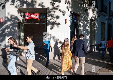 Pedestrians walk past the Spanish multinational manufacturing and footwear retail brand Camper store in Spain. Stock Photo