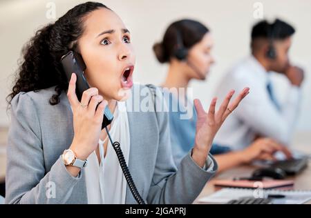 How many times do I have to explain the same thing. a young businesswoman looking stressed out while talking on a telephone in an office. Stock Photo