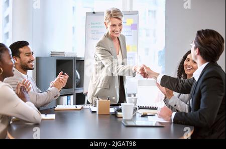 I would like to personally commend you on your performance. a senior businesswoman shaking hands with a colleague during a meeting in an office. Stock Photo