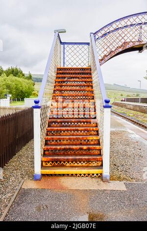 The rusty pedestrian footbridge over the tracks at the railway station in Achnasheen, a small village in Ross-shire, Highland council area,  Scotland Stock Photo