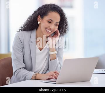 Everything looks good from where I am. an attractive young businesswoman sitting alone in her office and using her laptop. Stock Photo